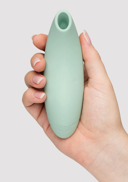 Mintgroene vibrator vastgehouden in hand, met open ronde opening
