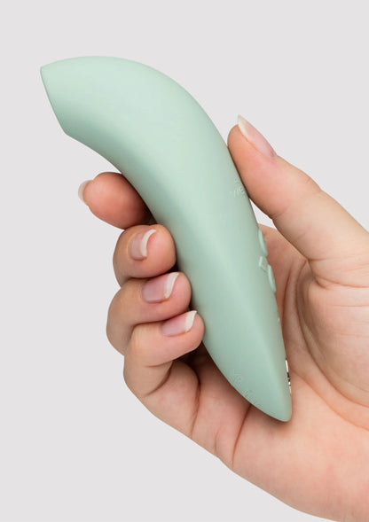 Mintgroene vibrator, close-up van gladde behuizing in hand