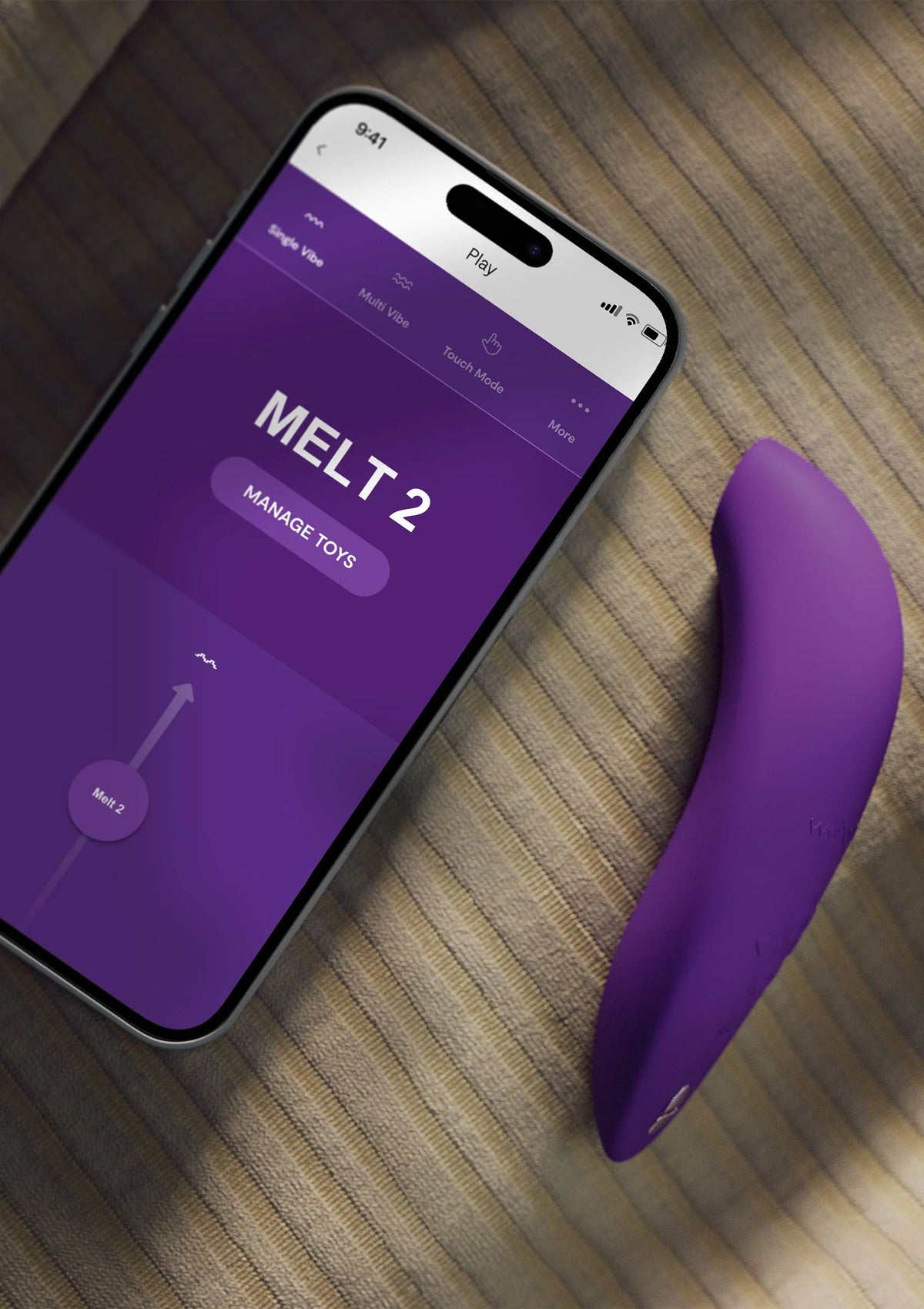 Donkerpaarse vibrator naast smartphone met app-scherm