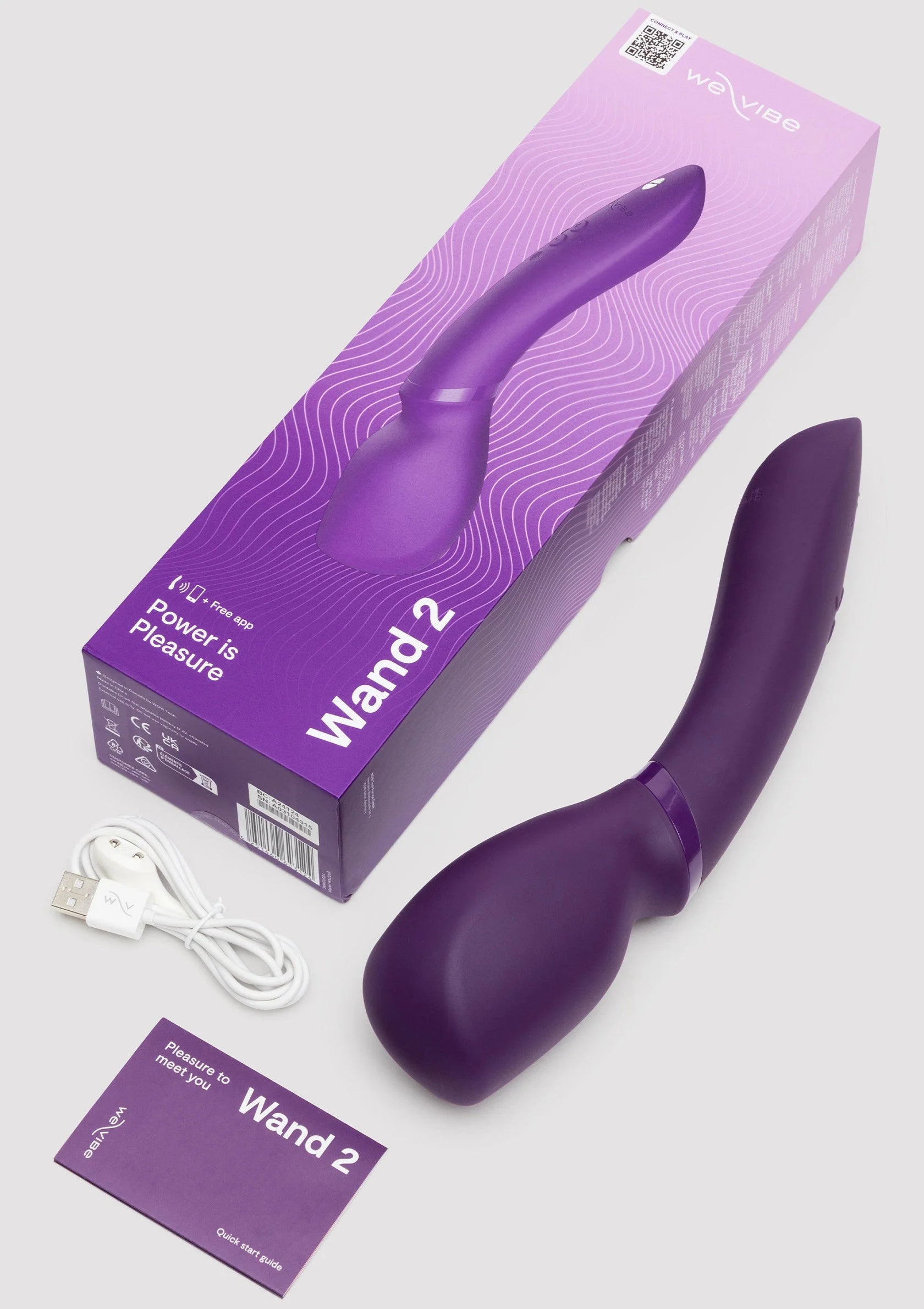 Verpakking en paars apparaat van We-Vibe Wand 2 met kabel en instructiekaart.