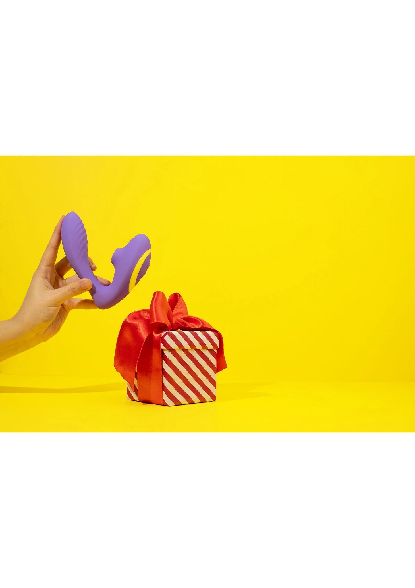 Paarse g-spot lucht-druk vibrator met gele rand, vastgehouden in hand
