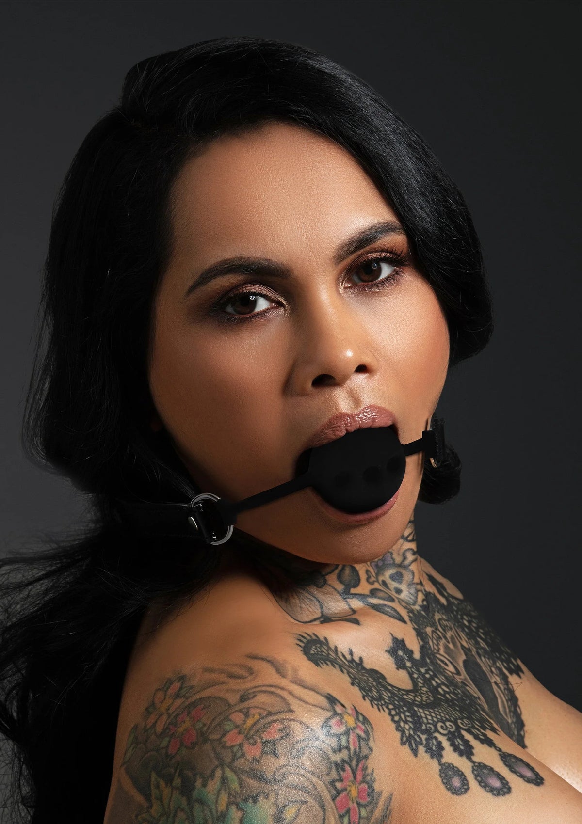 Zwarte siliconen ball gag met riemen, close-up op gezicht en hals
