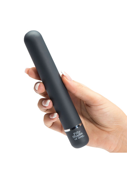 Zwarte staafvibrator in hand, afgeronde kop met 'Fifty Shades of Grey'-opdruk