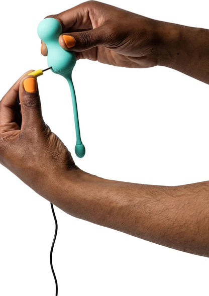 Teal G-spot tipvibrator in handen met kabel en oranje stekker zichtbaar